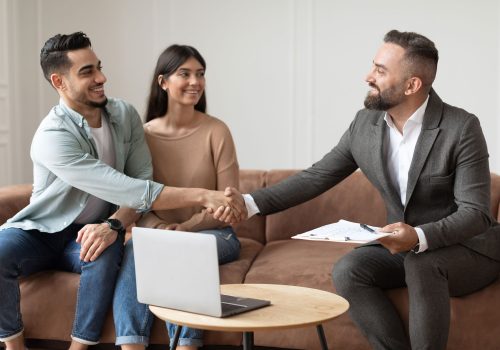 couple-buying-new-apartment-shaking-hands-with-re-2022-12-16-06-40-45-utc.jpg